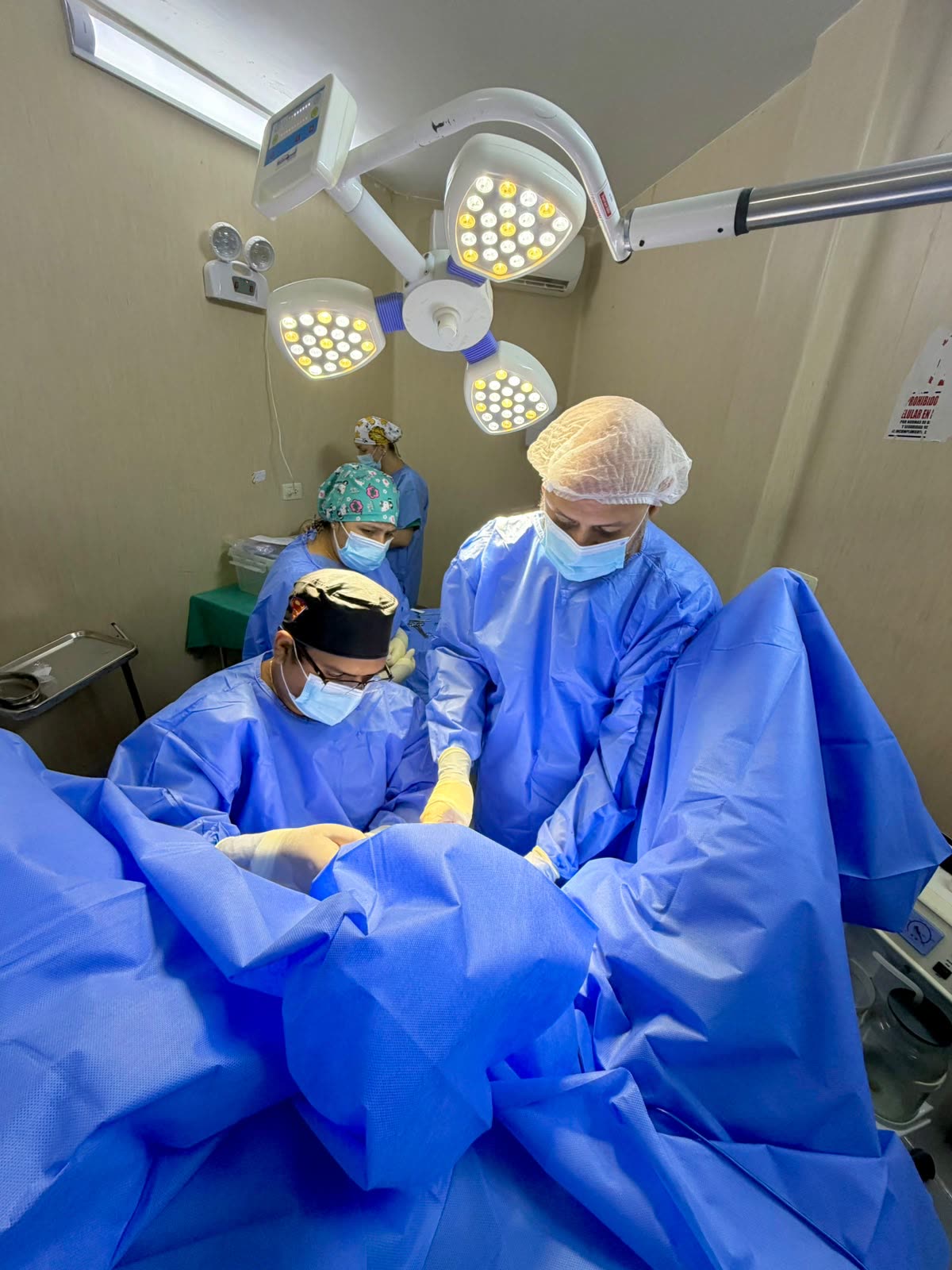 Cirujanos operando bajo lámparas quirúrgicas